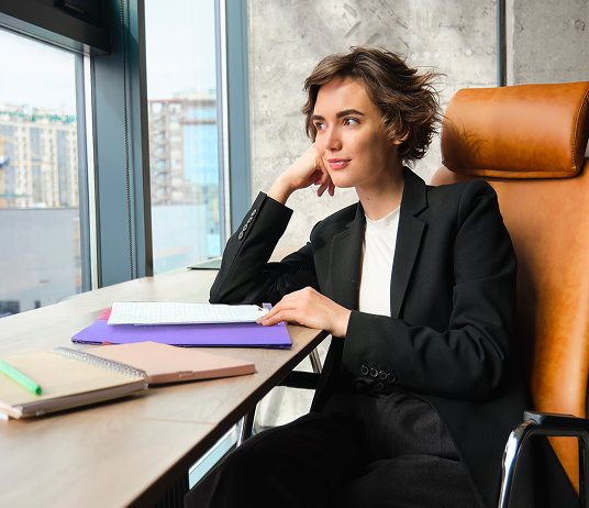 Una donna in ufficio che guarda verso la finestra